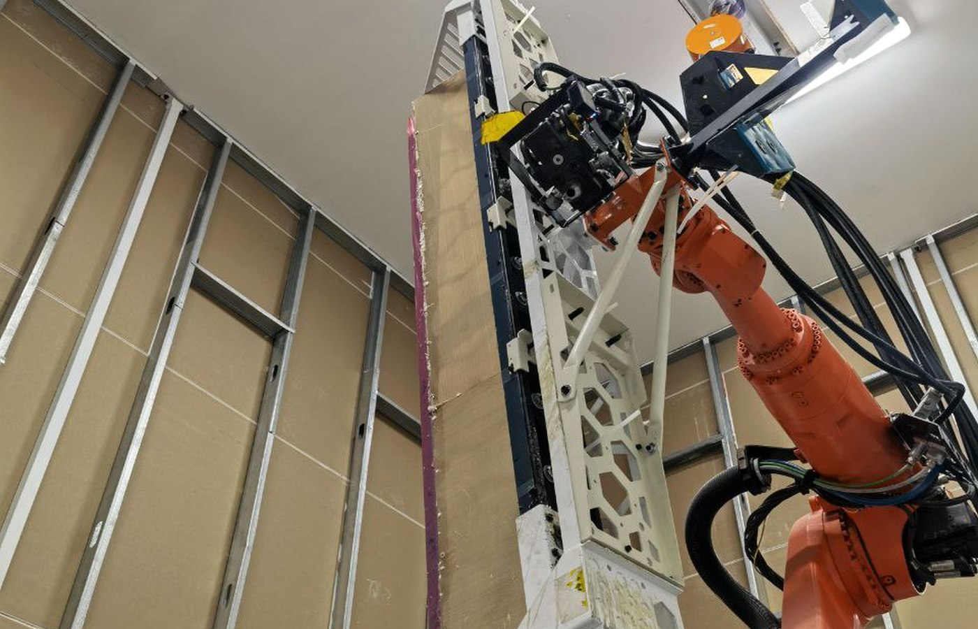 Large-format mechanical hold-down tooling installed on an industrial robot