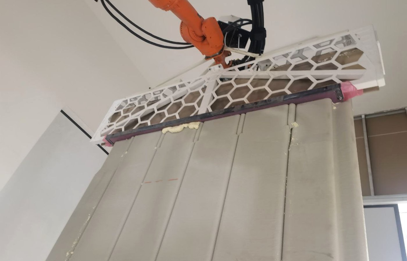 Mechanical hold-down tooling installed on an industrial robot